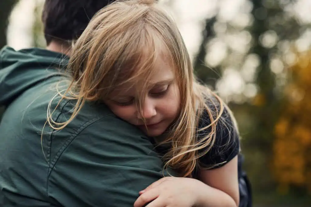 A father provides comfort to a child with a heartfelt hug